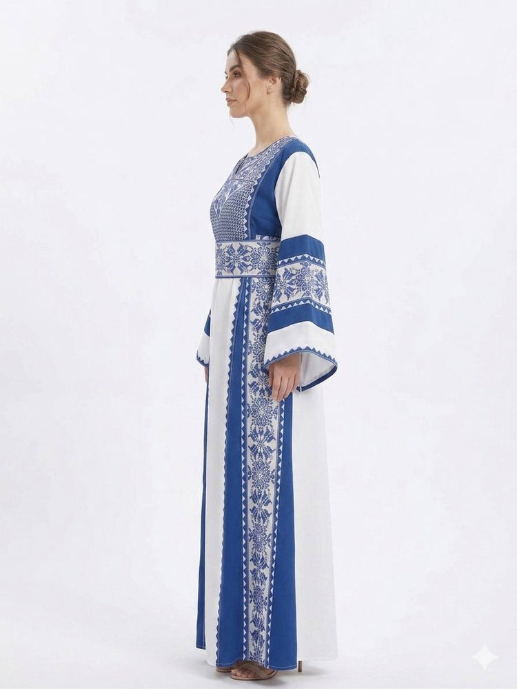 ثوب نسائي تراثي أبيض وأزرق مطرز بأكمام واسعة وتصميم أنيق مستوحى من التراث